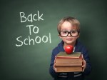 Young child holding stack of books and back to school written on