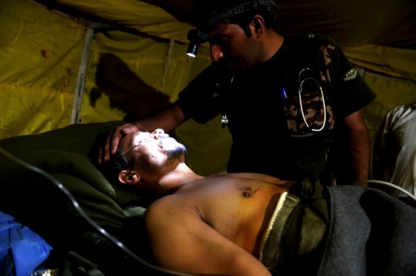 Injured Afghan policeman examined by Afghan Army doctor August 2015